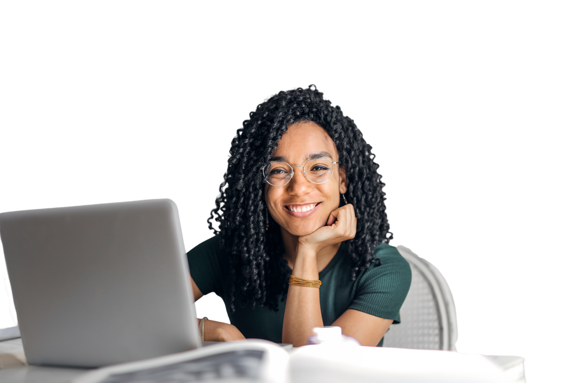 Happy ethnic woman sitting at table with laptop